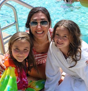 College student sitting by the pool with her campers while working at camp Bryn Mawr